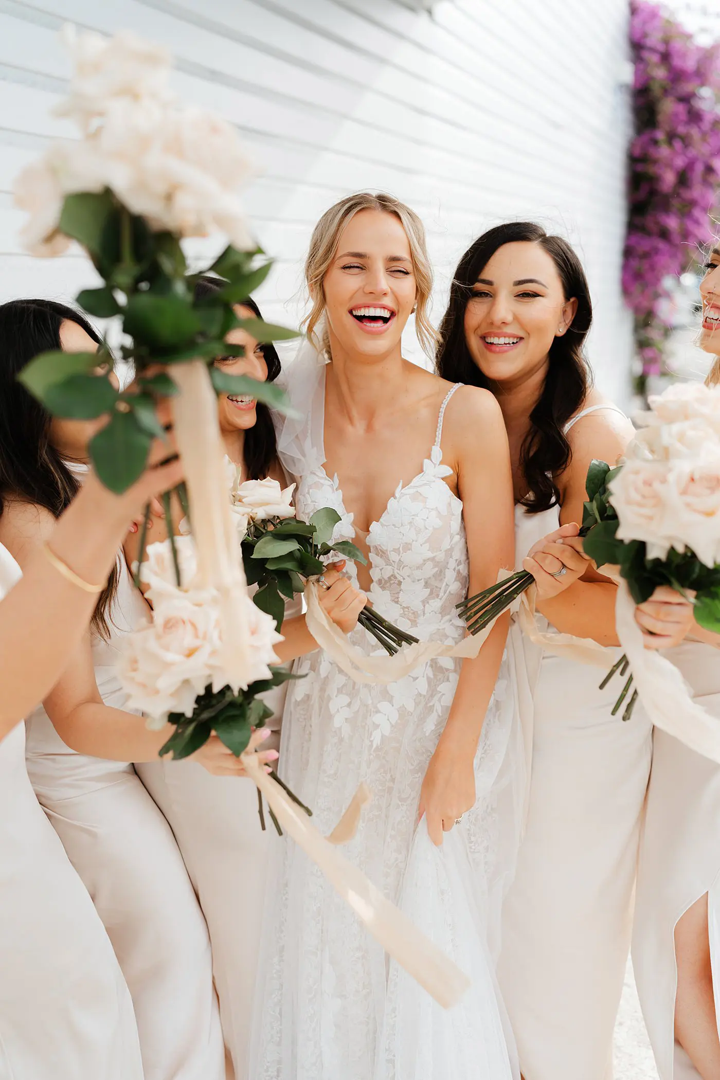 Bride and Bridesmaid having fun during their photoshoot holding folowers at ancora on the gold coast