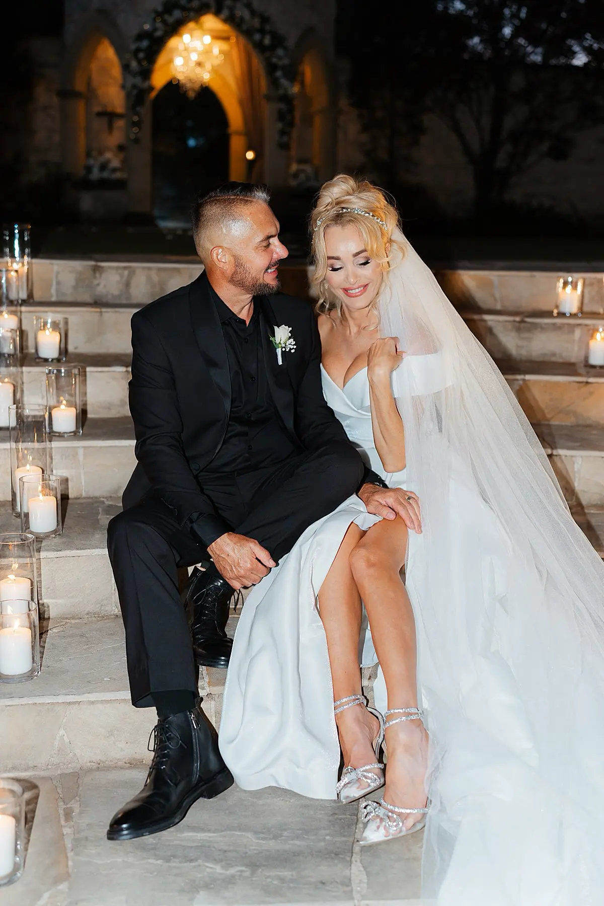 Night photo bride and groom sitting down on stairs with canldes at evergreen garden venue gold coast